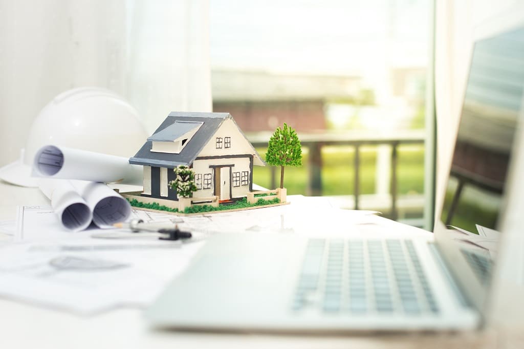 Decorative house next to a laptop