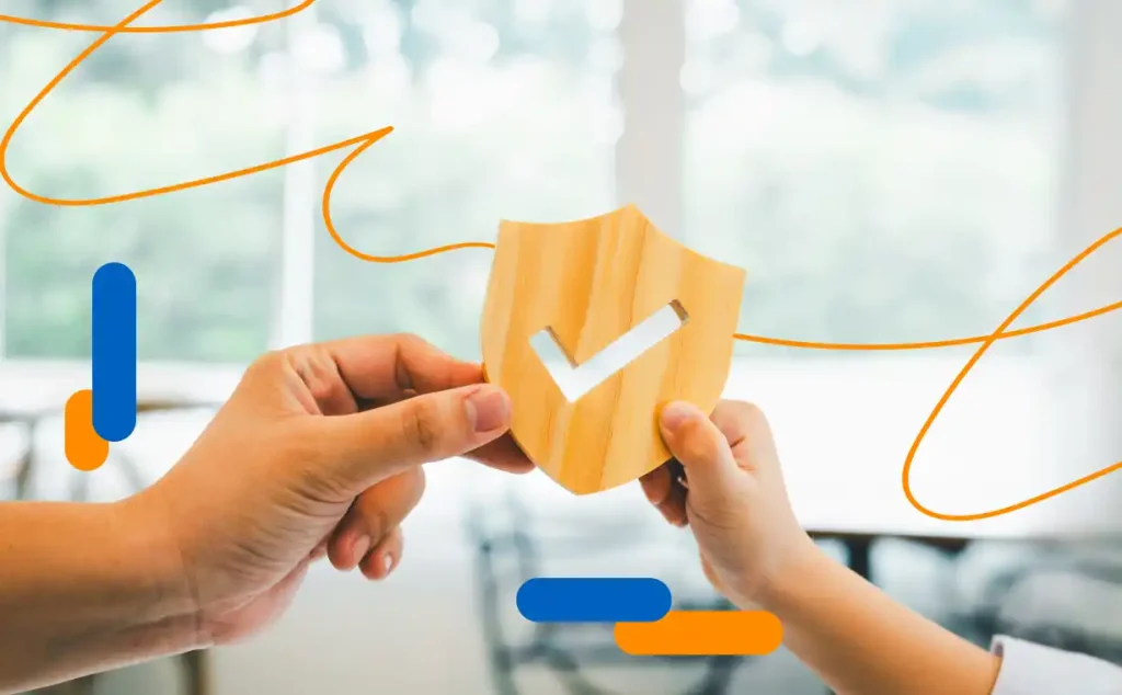 Two hands holding a wooden shield with a check, symbolizing protection and digital transformation and insurance trends 2025.