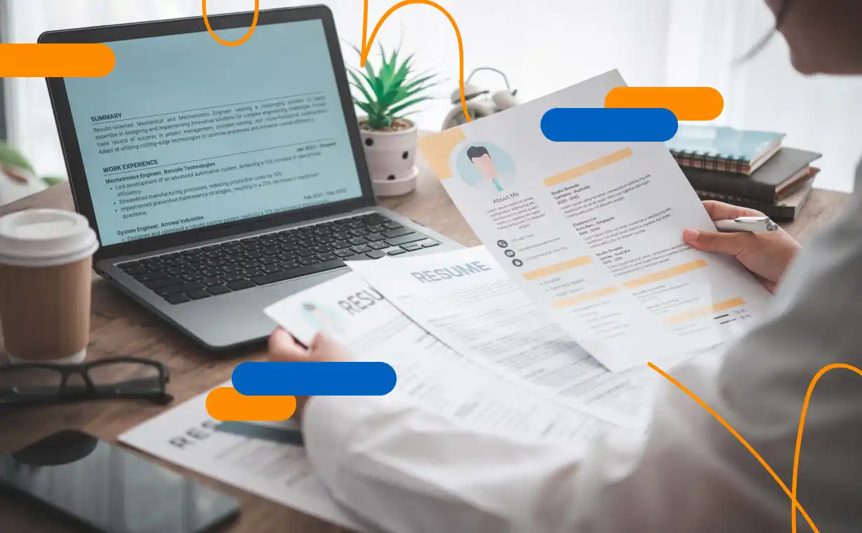 Person reviewing resumes in front of a laptop computer, in a selection process related to internship agreements