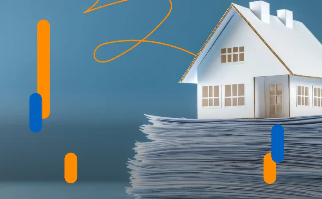 Model of a house on a pile of papers, symbolizing a digitized buying and selling properties