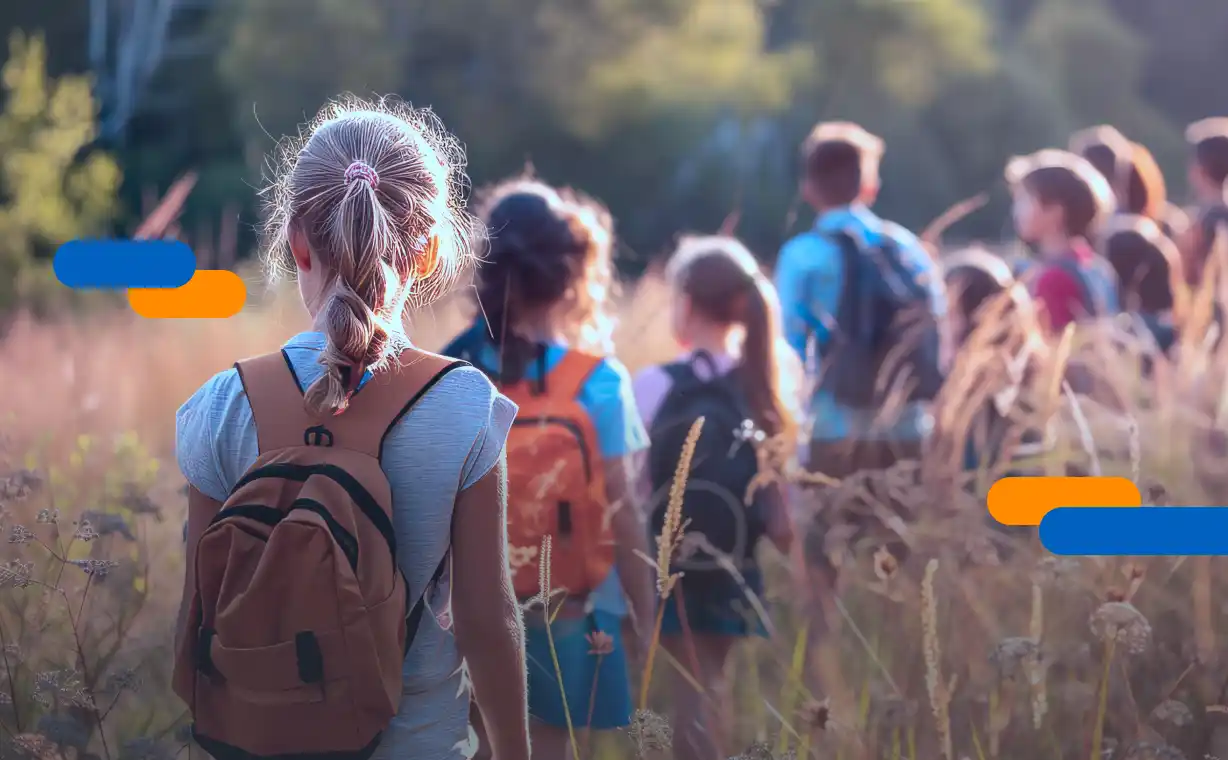 230626_blog_autorizaciones Grupo de niños con mochilas en. una excursión escolar en el campo, representando la importancia de firmar autorizaciones escolar